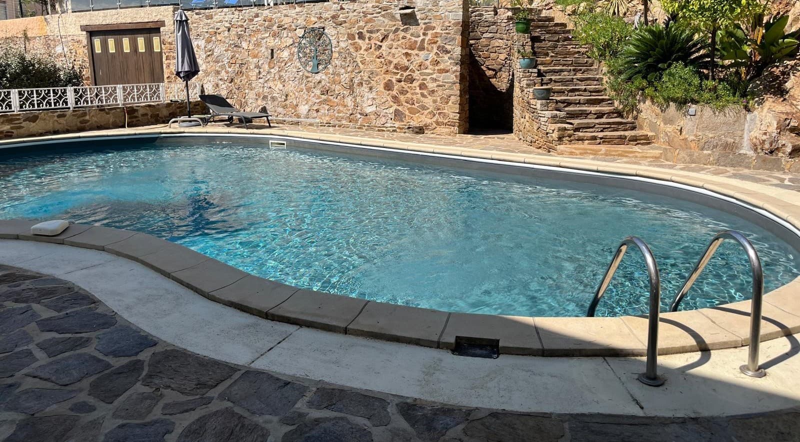 Piscine et mur en pierre